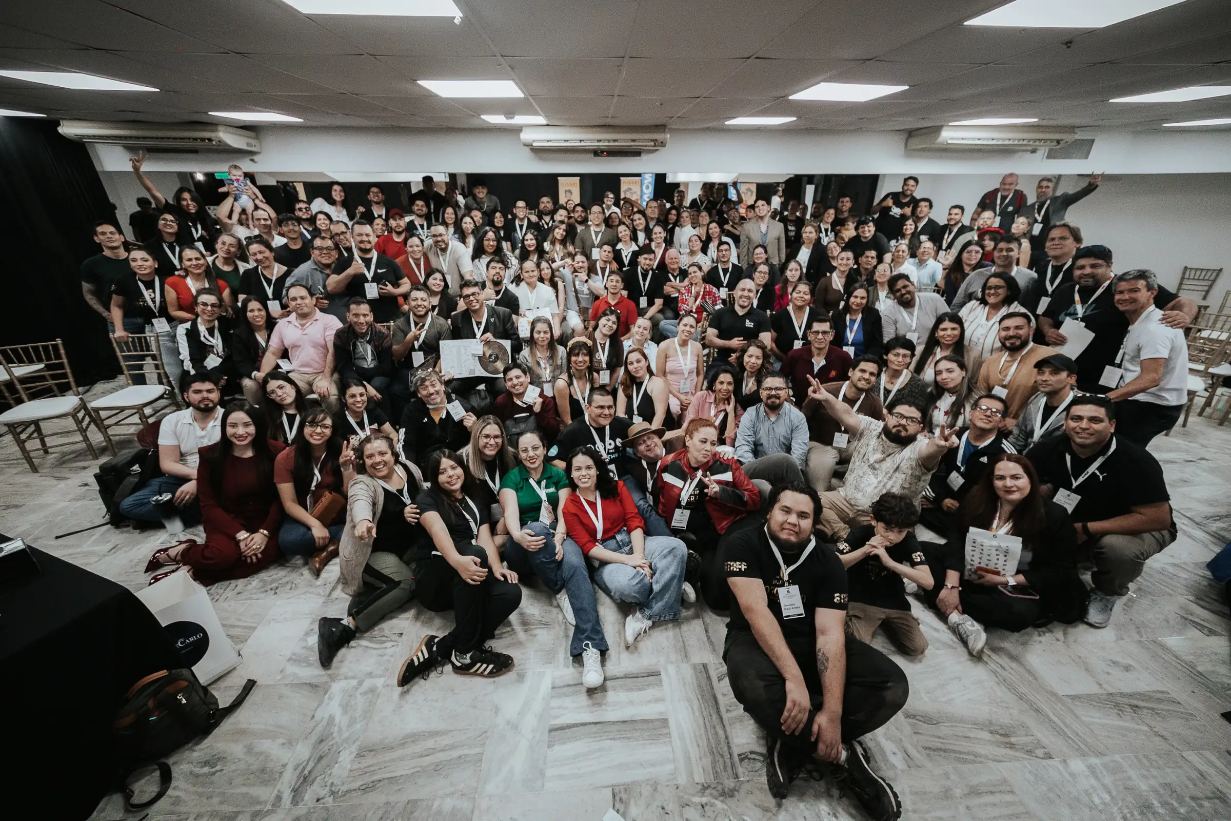Foto grupal del DDUF VI: cientos de fotógrafos sentados en el piso del salón